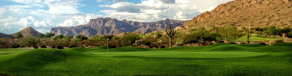 Gold Canyon Golf Resort fairway with desert mountains under a cloudy sky