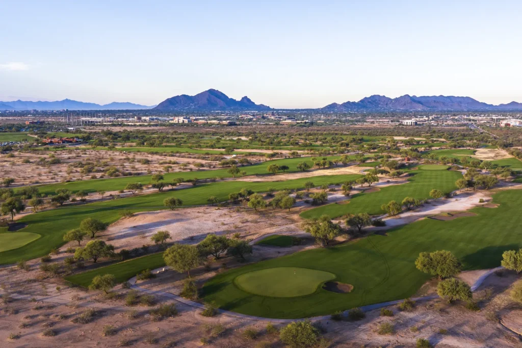 Talking Stick Golf Club green and desert bunkering with Camelback Mountain and Talking Stick Resort in the distance