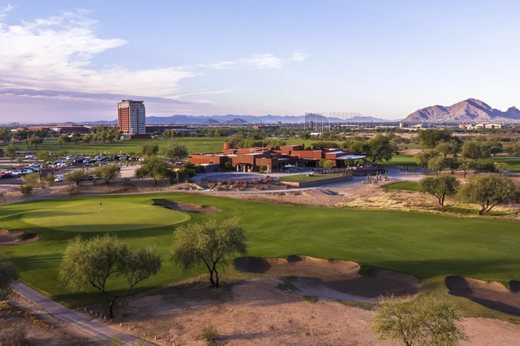 Talking Stick Golf Club green with the clubhouse, Talking Stick Resort tower and Camelback Mountain behind