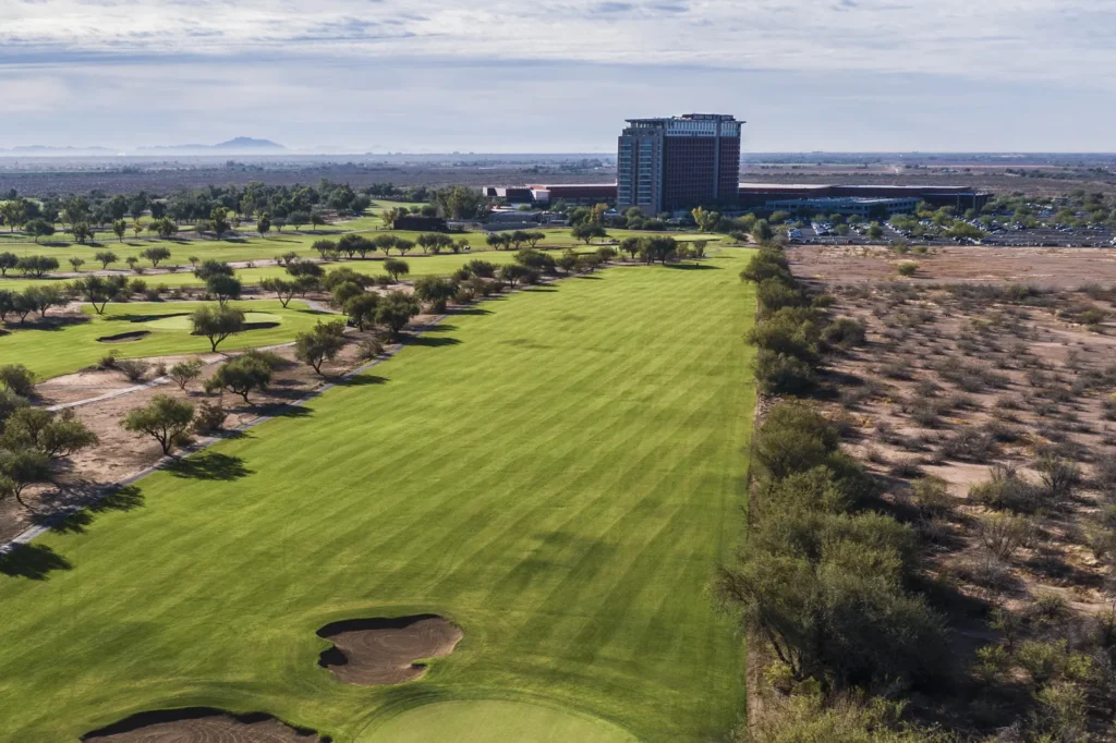 Tree-lined fairway leading toward the Talking Stick Resort tower at Talking Stick Golf Club