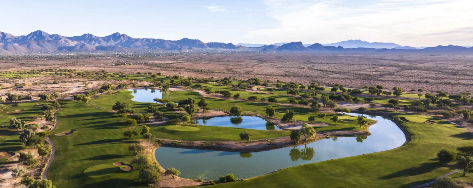Aerial view of lakes and fairways on the Piipaash Course at Talking Stick Golf Club with the McDowell Mountains behind, Scottsdale Arizona