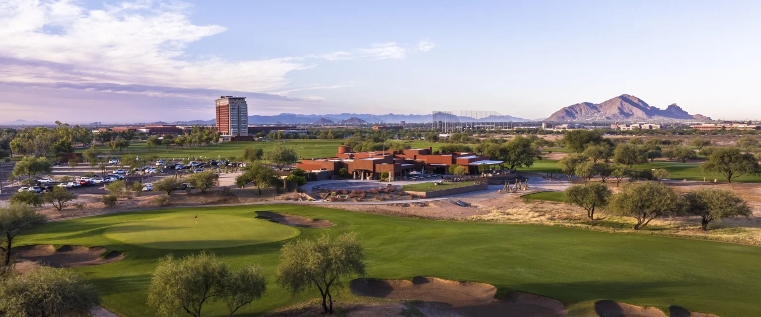 Talking Stick Resort tower and Camelback Mountain seen across a Talking Stick Golf Club green, Scottsdale Arizona